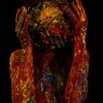 fotografie conceptuală artistică, portret fără chip, corp uman acoperit complet cu vopsea colorată groasă (roșu dominant, galben, albastru), fundal negru profund, iluminare dramatică low-key, persoană ținând cu ambele mâini un obiect sferic pictat care acoperă capul ca o mască sau o planetă abstractă, textură expresionistă, senzație de presiune emoțională, identitate ascunsă, simbolism legat de muzică interioară, atmosferă intensă, dark fine art photography, contrast puternic, compoziție centrală, ton introspectiv Prompt (EN – util pentru majoritatea platformelor): conceptual fine art portrait, faceless human figure covered in thick colorful paint (dominant red with yellow and blue), deep black background, dramatic low-key lighting, subject holding a painted spherical object covering the head like a mask or abstract planet, expressionist texture, emotional pressure symbolism, hidden identity, inner music metaphor, intense mood, high contrast studio photography