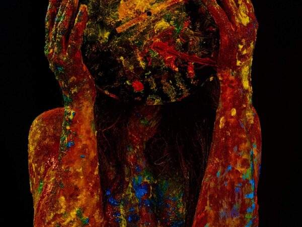 fotografie conceptuală artistică, portret fără chip, corp uman acoperit complet cu vopsea colorată groasă (roșu dominant, galben, albastru), fundal negru profund, iluminare dramatică low-key, persoană ținând cu ambele mâini un obiect sferic pictat care acoperă capul ca o mască sau o planetă abstractă, textură expresionistă, senzație de presiune emoțională, identitate ascunsă, simbolism legat de muzică interioară, atmosferă intensă, dark fine art photography, contrast puternic, compoziție centrală, ton introspectiv Prompt (EN – util pentru majoritatea platformelor): conceptual fine art portrait, faceless human figure covered in thick colorful paint (dominant red with yellow and blue), deep black background, dramatic low-key lighting, subject holding a painted spherical object covering the head like a mask or abstract planet, expressionist texture, emotional pressure symbolism, hidden identity, inner music metaphor, intense mood, high contrast studio photography